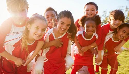 group of kids wearing sports jerseys at soccer game